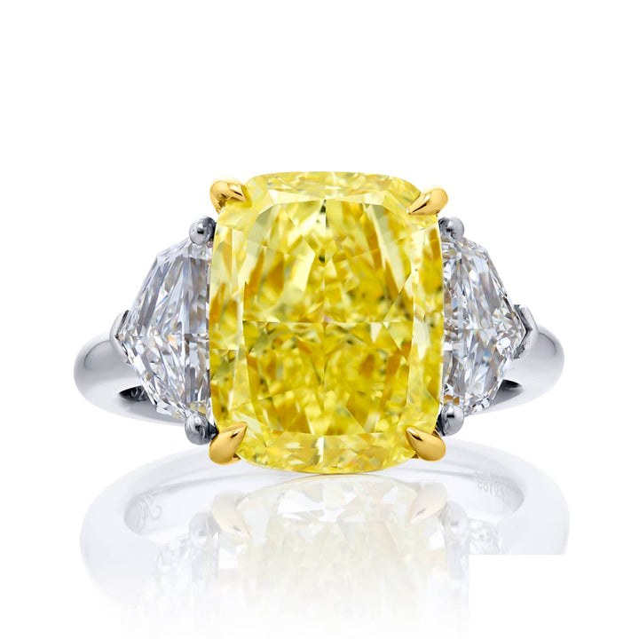 Dazzling Brilliance: Our magnificent 6.02 ct. GIA certified Fancy Yellow Diamond Ring. This stunning cushion-cut fancy yellow diamond flanked by epaulet diamonds is handcrafted in pure platinum and 18KY gold.