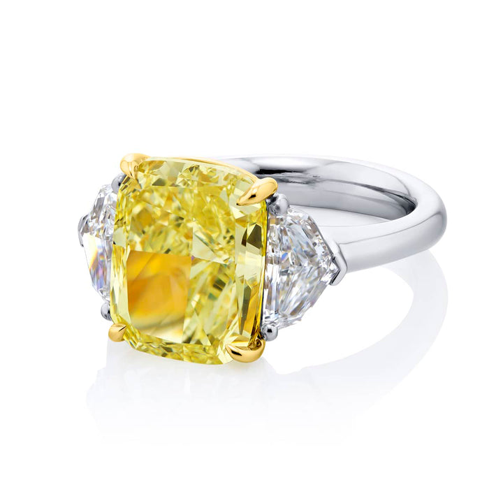 Dazzling Brilliance: Our magnificent 6.02 ct. GIA certified Fancy Yellow Diamond Ring. This stunning cushion-cut fancy yellow diamond flanked by epaulet diamonds is handcrafted in pure platinum and 18KY gold.