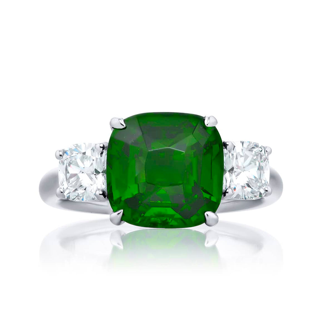 Breathtaking Radiance: Our stunning 5.11 ct. GIA certified Green Tsavorite Ring. This gorgeous cushion-cut green tsavorite embraced by cushion-cut diamonds is handcrafted in pure platinum.