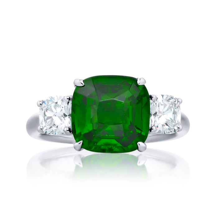 Breathtaking Radiance: Our stunning 5.11 ct. GIA certified Green Tsavorite Ring. This gorgeous cushion-cut green tsavorite embraced by cushion-cut diamonds is handcrafted in pure platinum.