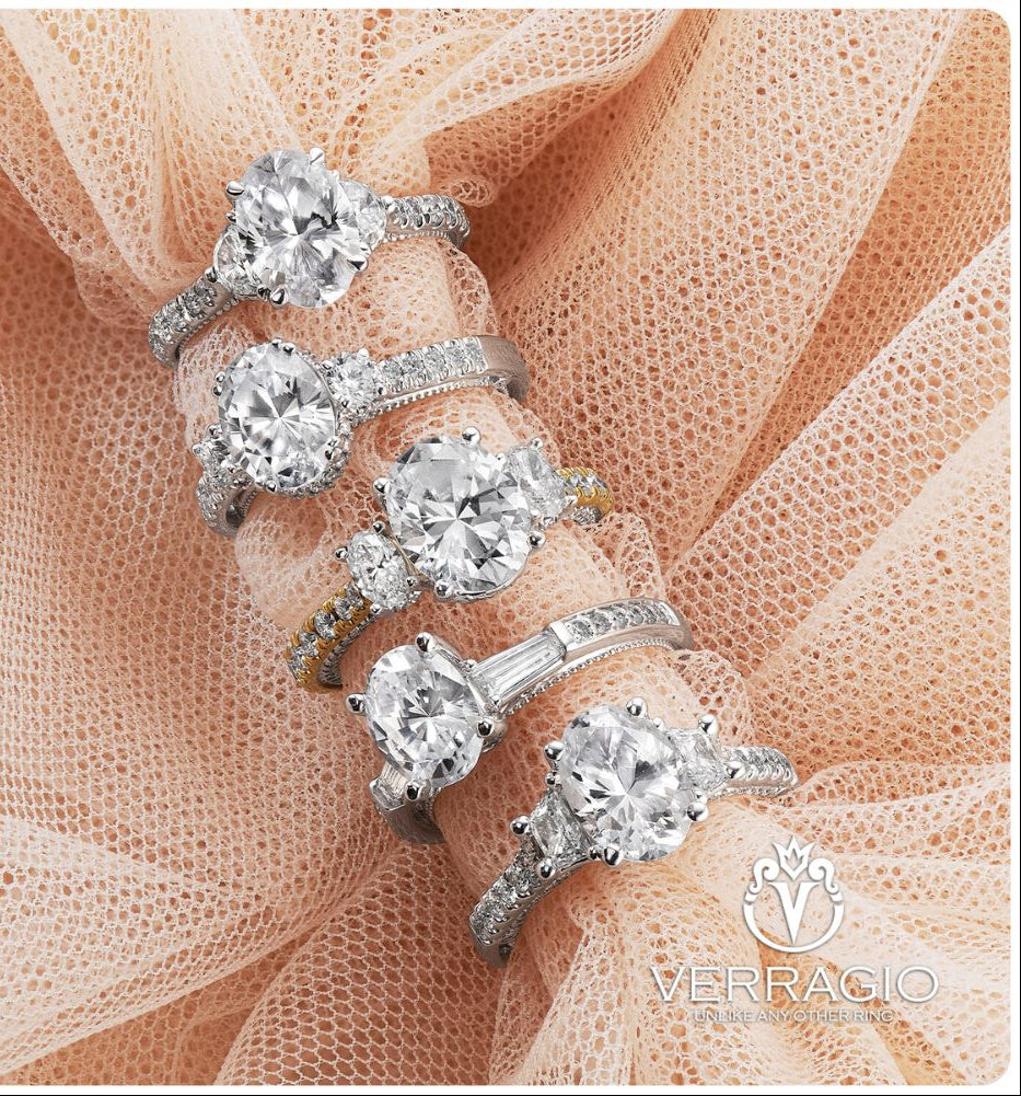 Set of diamond rings on a soft fabric background with Verragio logo.