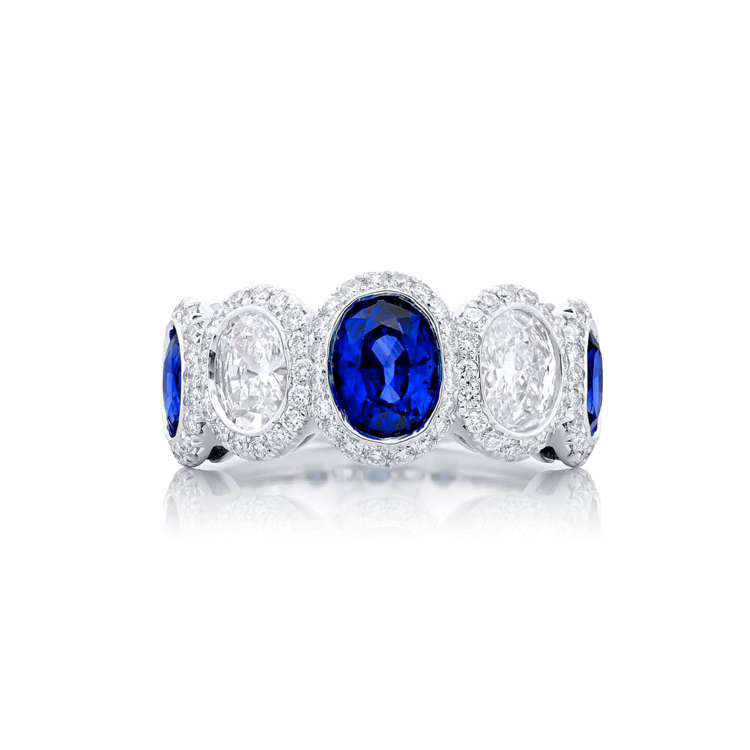 Elegance Elevated: Our signature Bezel Sapphire Band. These gorgeous oval sapphires and diamonds cradled in micro pave diamonds are handcrafted in pure platinum.