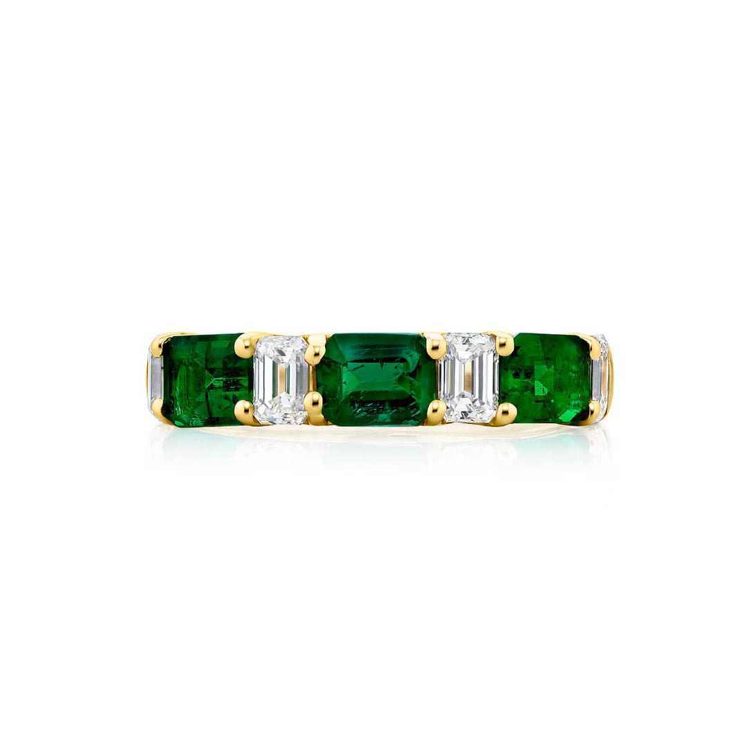 Elegance Elevated: Our classic single row East-West Emerald Band. These stunning emerald-cut emeralds accompany emerald-cut diamonds and are handcrafted in 18KY gold.