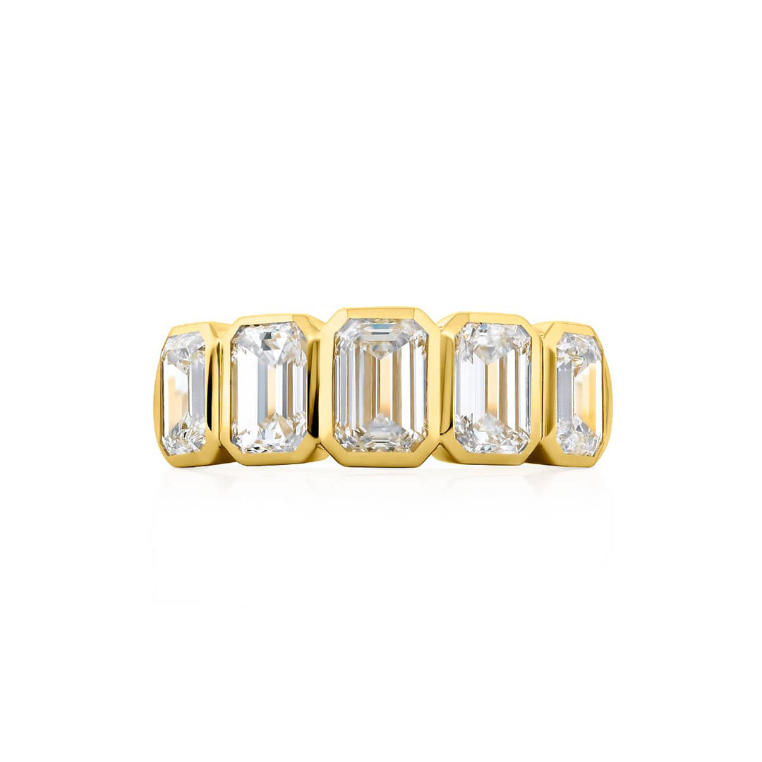 Elegance Elevated: Our stunning 3.20 ctw. Bezel Diamond Band. These five beautiful emerald-cut diamonds are handcrafted in 18KY gold.