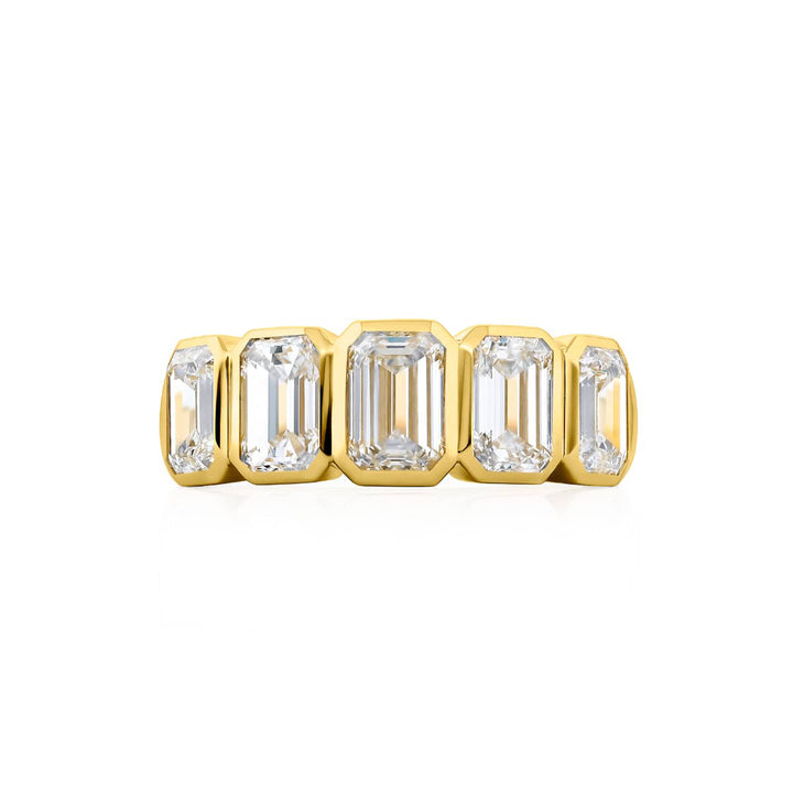 Elegance Elevated: Our stunning 3.20 ctw. Bezel Diamond Band. These five beautiful emerald-cut diamonds are handcrafted in 18KY gold.