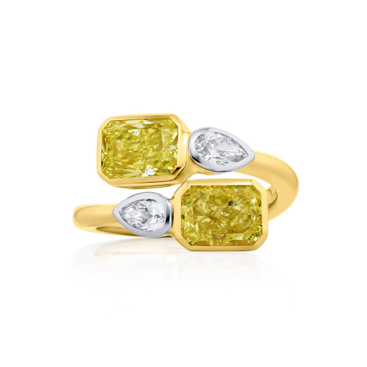 Dazzling Brilliance: Our unique 3.18 ctw. GIA certified Bezel Twogether Fancy Yellow Diamond Ring. These stunning radiant-cut fancy yellow diamonds accompanied by dazzling pear-shaped diamonds are handcrafted in 18KY gold and pure platinum.