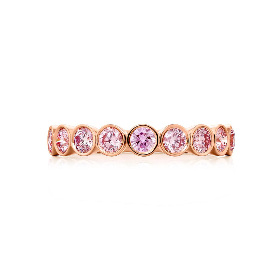 Elegance Elevated: Our stunning 0.95 ctw. East-West Bezel Pink Diamond Band. These nine beautiful round pink diamonds are handcrafted in 18K pink gold.