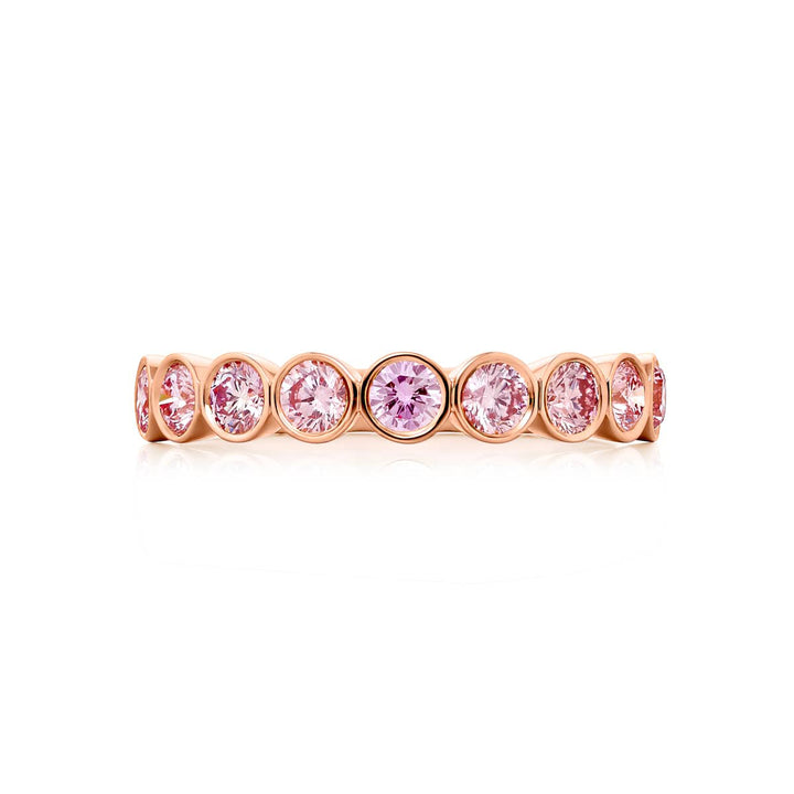 Elegance Elevated: Our stunning 0.95 ctw. East-West Bezel Pink Diamond Band. These nine beautiful round pink diamonds are handcrafted in 18K pink gold.