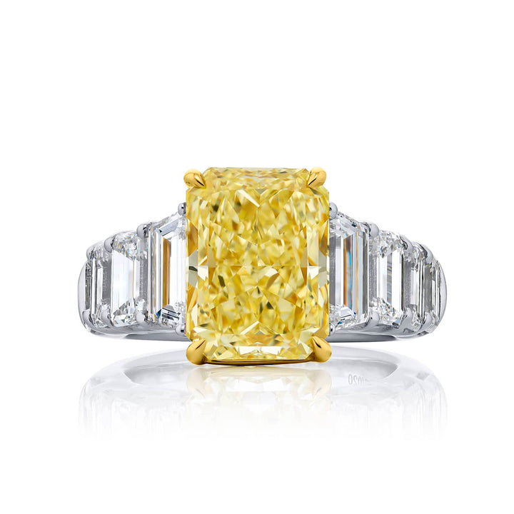 Dazzling Brilliance: Our magnificent 5.14 ct. GIA certified Fancy Yellow Diamond Ring. This beautiful radiant-cut fancy yellow diamond flanked by emerald-cut and tapered baguette diamonds is handcrafted in pure platinum and 18KY gold.
