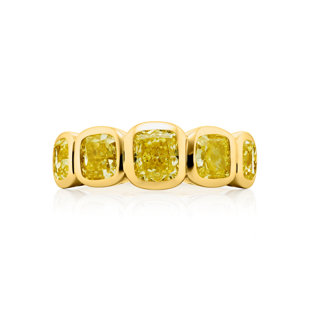 Elegance Elevated: Our stunning 3.55 ctw. Bezel Fancy Yellow Diamond Band. These five beautiful cushion-cut fancy yellow diamonds are handcrafted in 18KY gold.