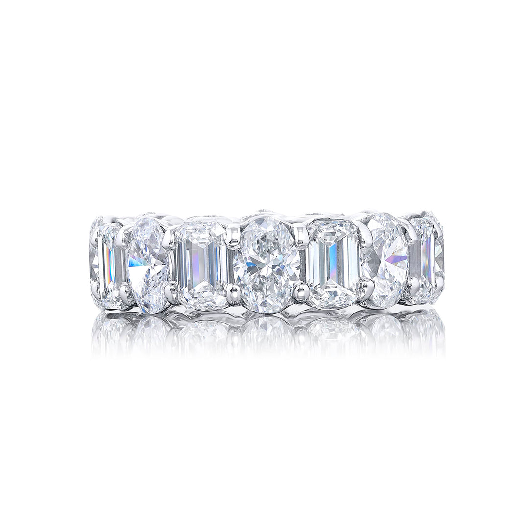 Stunning eternity band featuring 16 stones alternating between oval and emerald cut diamonds in shared prong setting. Handcrafted in pure platinum.