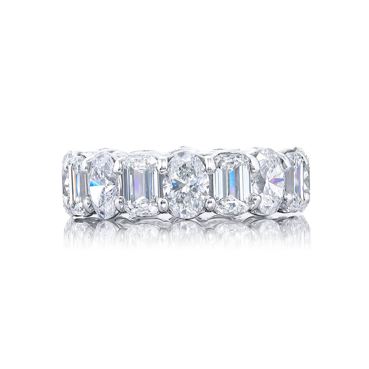 Stunning eternity band featuring 16 stones alternating between oval and emerald cut diamonds in shared prong setting. Handcrafted in pure platinum.