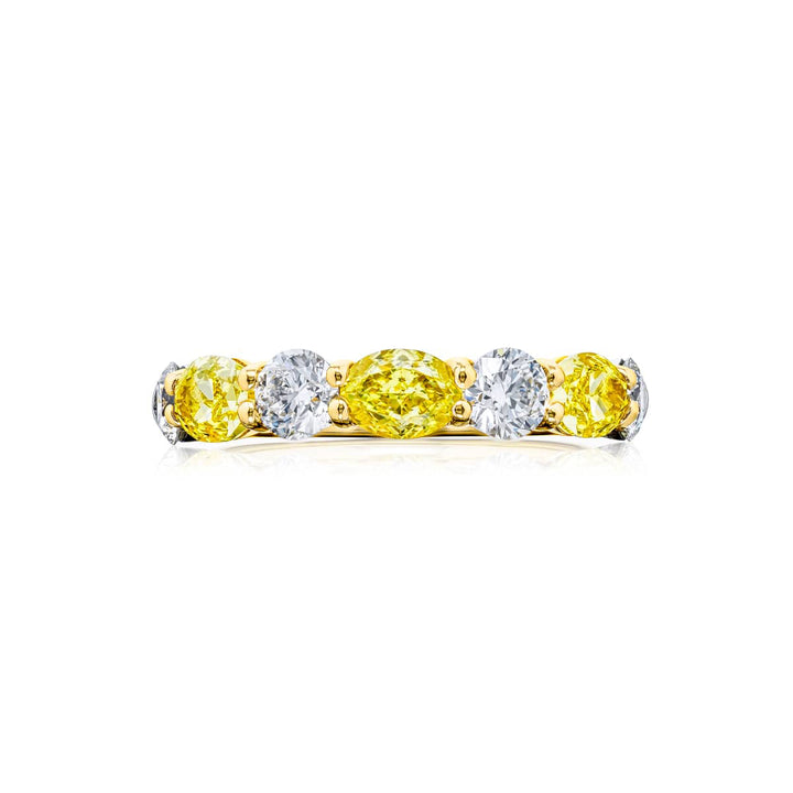 Elegance Elevated: Our classic single row East-West Fancy Yellow & White Diamond Band. These oval fancy yellow diamonds accompany round white diamonds and are handcrafted in 18KY gold.