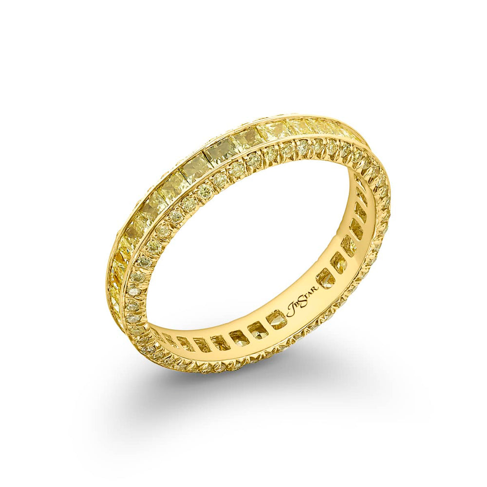 Alluring Eternity: Our beautiful single row Fancy Yellow Diamond Eternity Band. These stunning princess-cut fancy yellow diamonds blend with pave diamonds and are handcrafted in 18KY gold.
