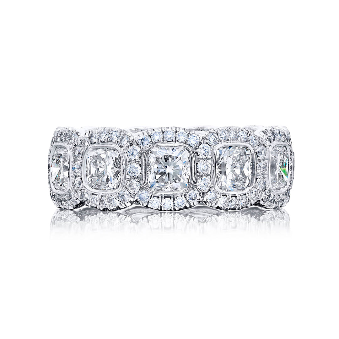 Alluring Eternity: Our stunning single-row Bezel Set Diamond Eternity Band. These eleven cushion-cut diamonds embraced by micro pave diamonds are handcrafted in pure platinum.
