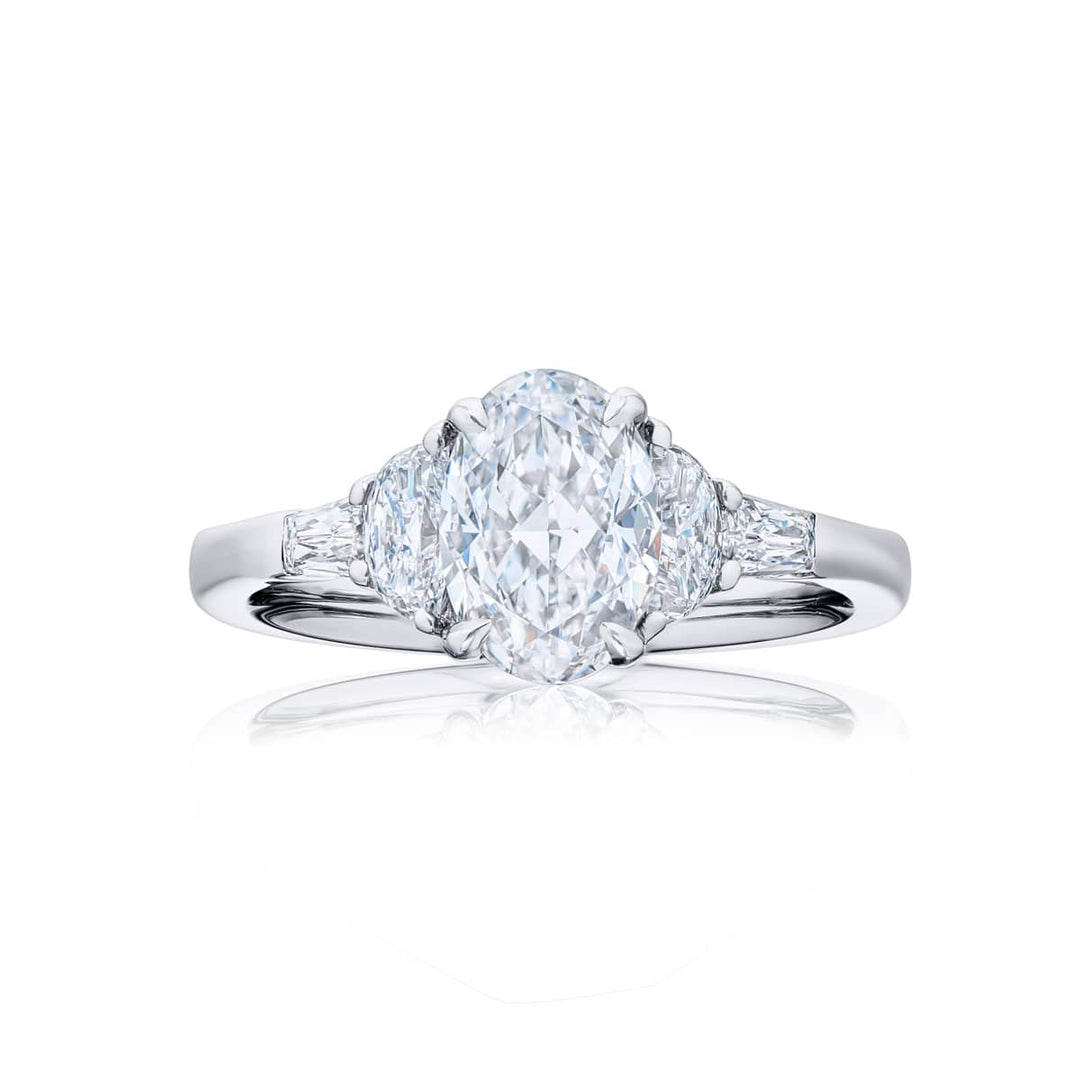 Dazzling Brilliance: Our timeless 1.50ct GIA-certified diamond ring. This oval-cut diamond is flanked by half-moon diamonds and tapered baguettes meticulously handcrafted in pure platinum.