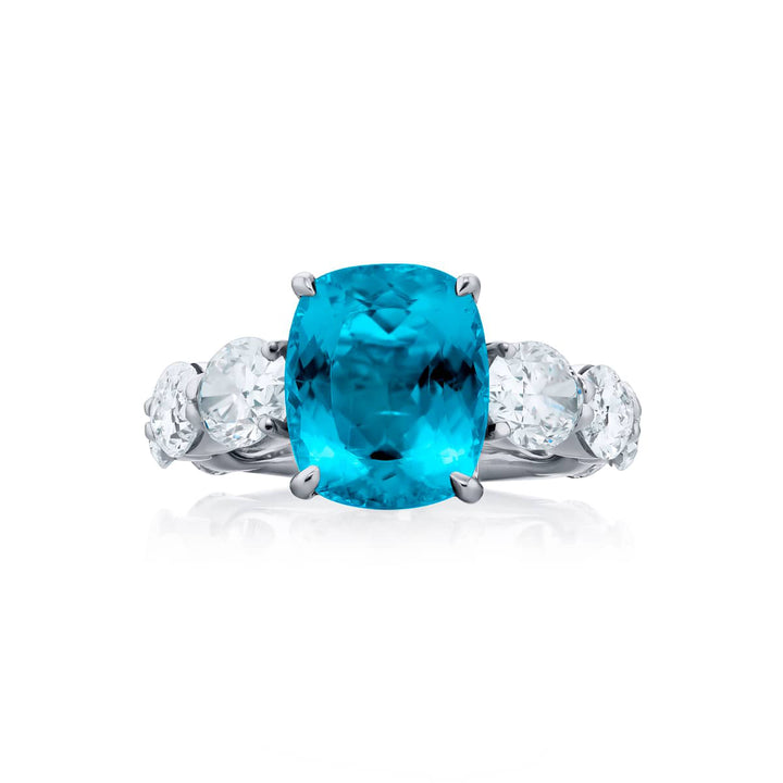 Breathtaking Radiance: Our beautiful 4.23 ct. certified Paraiba Ring. This stunning cushion-cut paraiba flanked by dazzling oval diamonds is handcrafted in pure platinum.