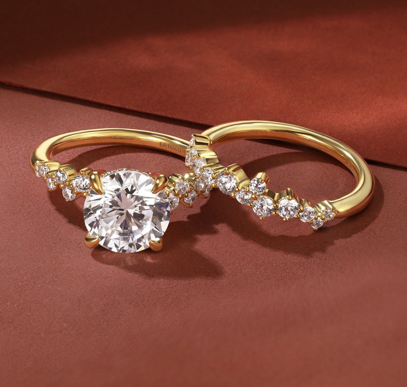 Gold ring with a diamond on a red background, featuring the brand 'Gabriel & Co'.