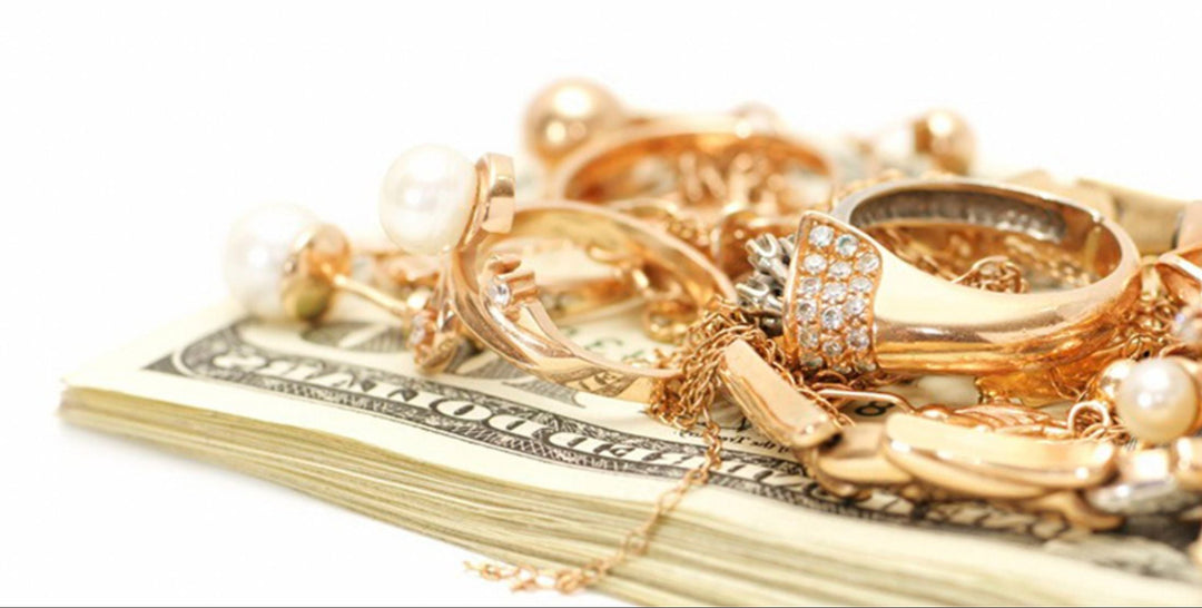 Gold jewelry and dollar bills on a white background